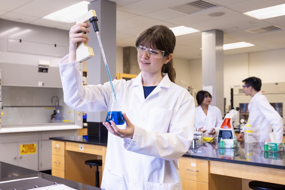 Madeleine in a lab conducting an experiment with classmates